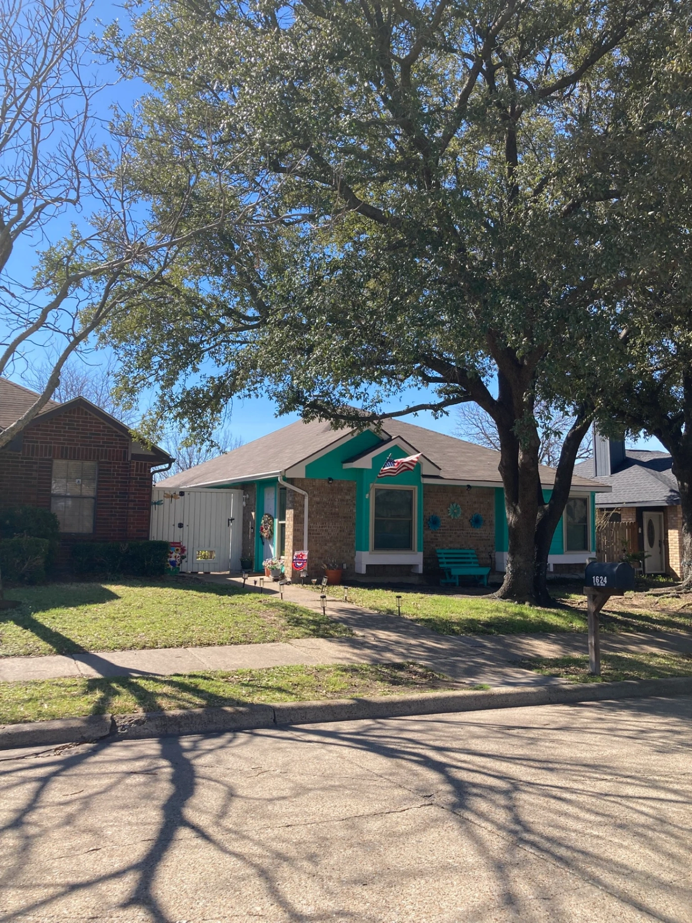 Mesquite Texas residential home with charming front porch and mature trees in a family-friendly DFW metroplex neighborhood